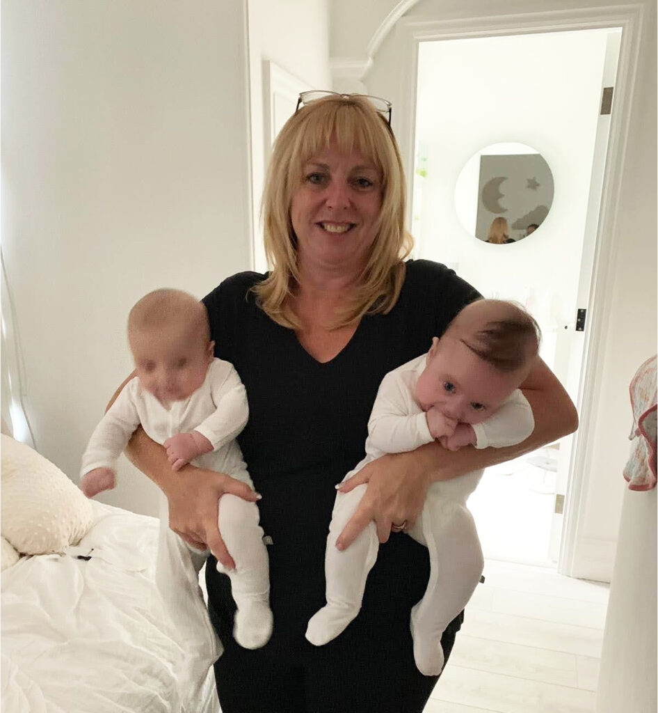 Photo of Lesley holding twin babies